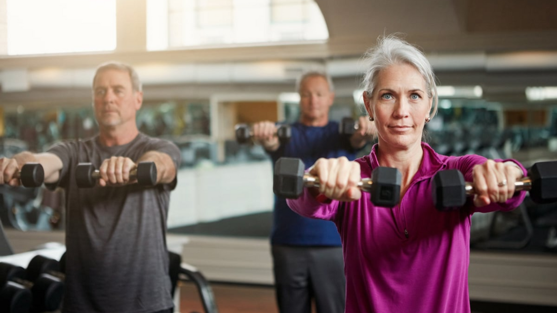 Older adults confidently lifting weights in a gym, promoting active aging and fitness beyond 40.
